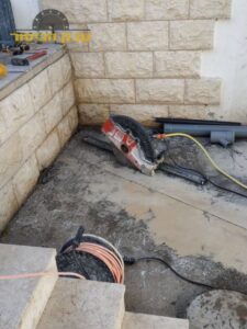 ניסור ופירוק של משטח בטון בחצר בבניין